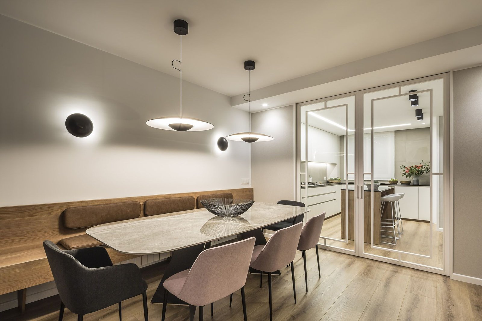 Interiorismo vivienda Valencia, zona bancada y mesa centro con sillas diferentes colores
