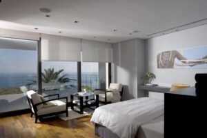 Amplio dormitorio con vistas al mar, decoración y sillones de descanso.