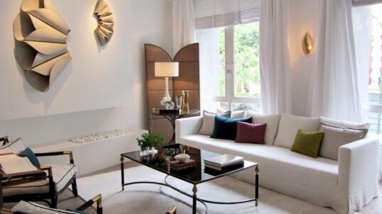 Zona sala de estar en tonos claros sofás y butacas